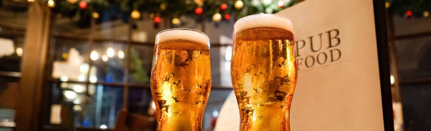 Inside a traditional English pub with two beers and a menu