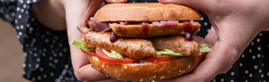 Close-up shot of a person holding a bagel from the Bagel Factory.