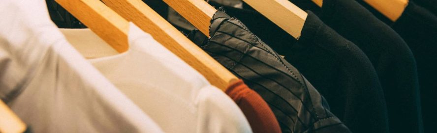 Clothes hanging up on a hanger in a wardrobe.