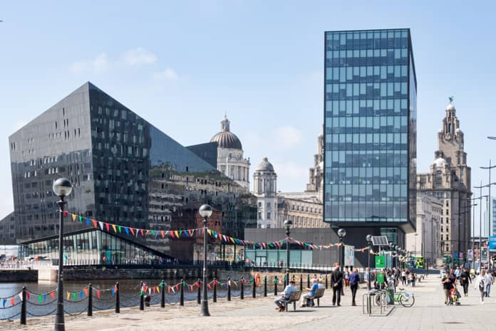The Liverpool waterfront on a sunny day with the Liver Bird Building in the background.